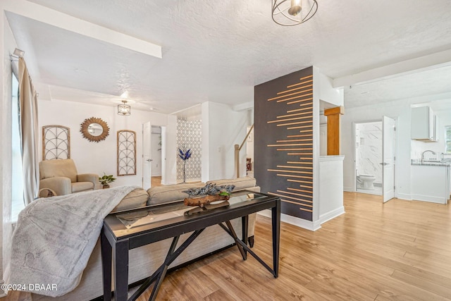 living room with a textured ceiling, hardwood / wood-style flooring, and sink