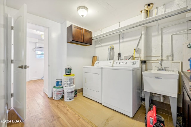 washroom with cabinets, separate washer and dryer, and light wood-type flooring