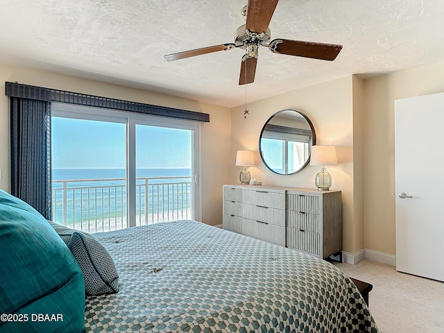 3333 S Atlantic Ave Unit 505, Daytona Beach, FL 32118 - bedroom featuring access to outside, a textured ceiling, a water view, light carpet, and a ceiling fan
