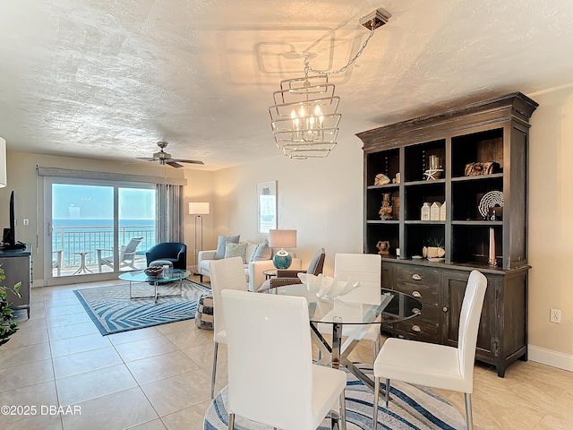 3333 S Atlantic Ave Unit 505, Daytona Beach, FL 32118 - dining space featuring ceiling fan, light tile patterned flooring, a chandelier, baseboards, and a textured ceiling