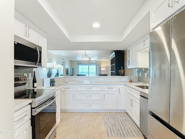 3333 S Atlantic Ave Unit 505, Daytona Beach, FL 32118 - kitchen with appliances with stainless steel finishes, a peninsula, decorative backsplash, white cabinets, and recessed lighting