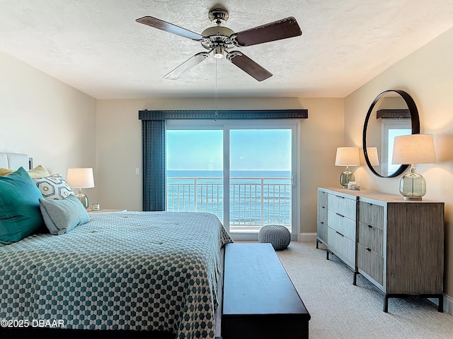 3333 S Atlantic Ave Unit 505, Daytona Beach, FL 32118 - bedroom featuring light colored carpet, access to exterior, baseboards, ceiling fan, and a textured ceiling