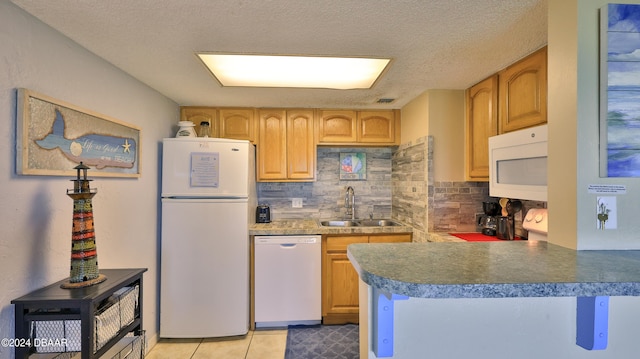 kitchen with kitchen peninsula, tasteful backsplash, a textured ceiling, white appliances, and sink