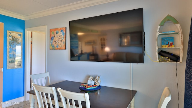 tiled dining area featuring crown molding