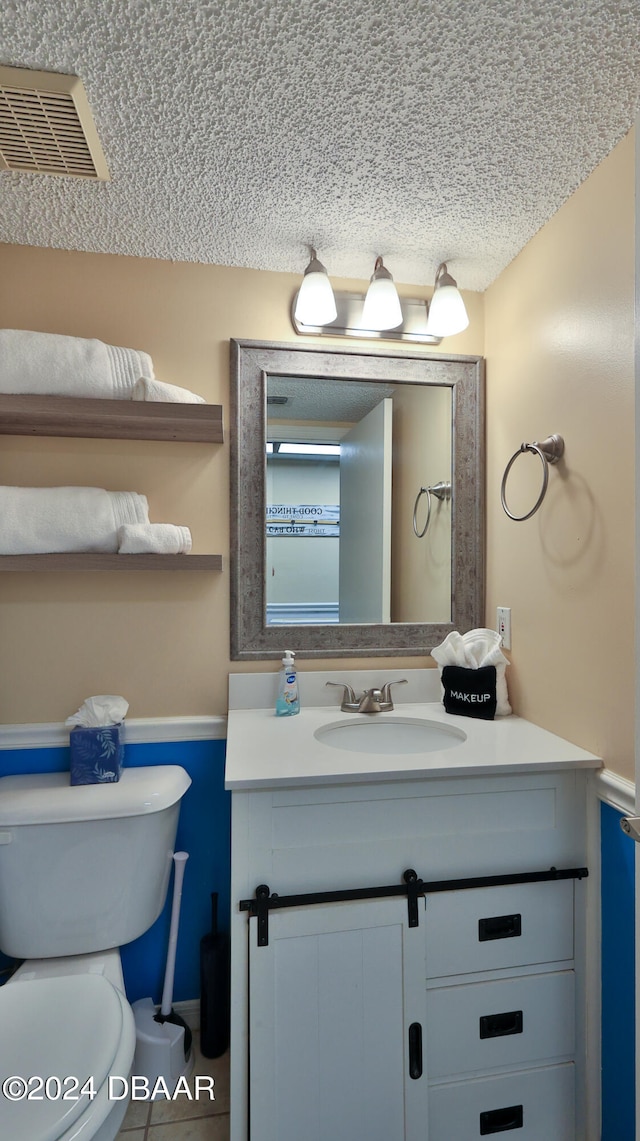 bathroom featuring tile patterned flooring, vanity, and toilet