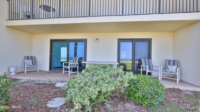 doorway to property with a balcony and a patio area