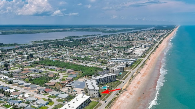 birds eye view of property with a water view and a beach view