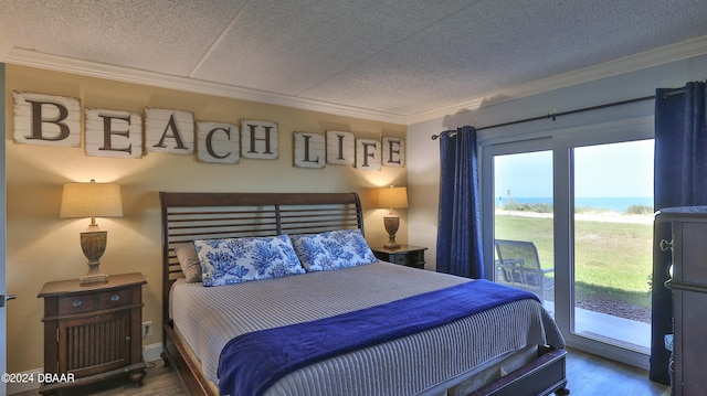 bedroom with hardwood / wood-style flooring, ornamental molding, and access to outside