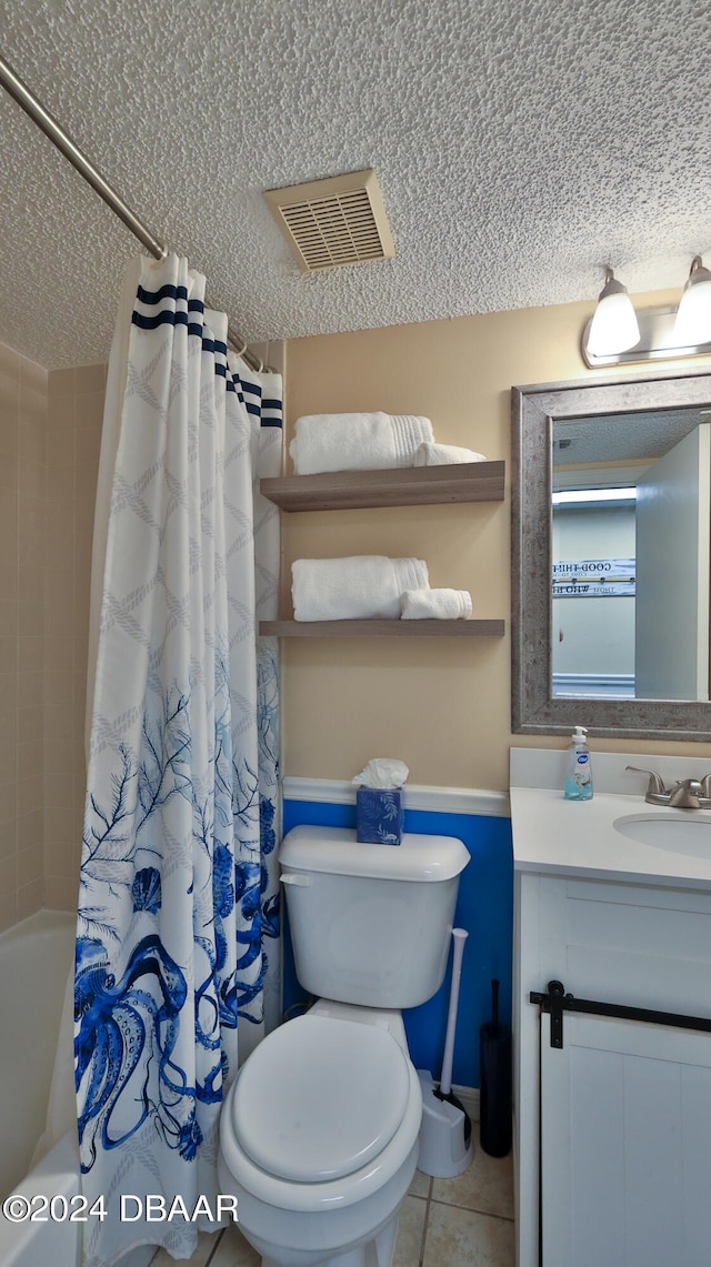 full bathroom featuring vanity, tile patterned floors, shower / bath combination with curtain, toilet, and a textured ceiling