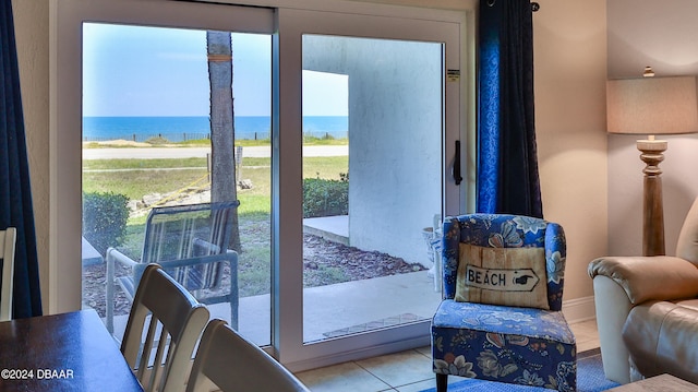 doorway to outside with a water view and light tile patterned flooring