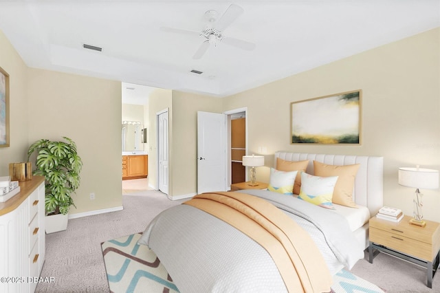 bedroom featuring connected bathroom, light colored carpet, and ceiling fan