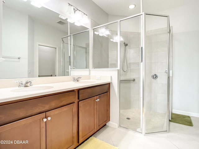 bathroom with tile patterned floors, a shower with door, and vanity