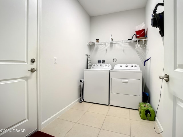 laundry room featuring separate washer and dryer and light tile patterned floors