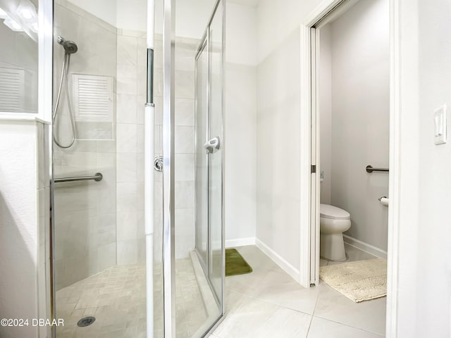 bathroom featuring tile patterned flooring, toilet, and walk in shower