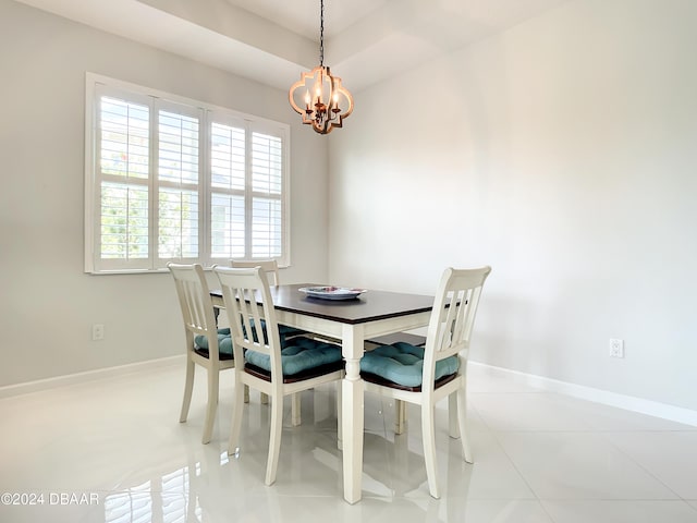 dining area featuring light tile patterned flooring, a tray ceiling, a wealth of natural light, and an inviting chandelier