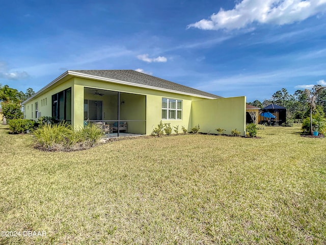 back of property with a sunroom and a lawn