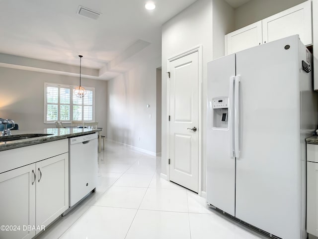 kitchen featuring white appliances, sink, decorative light fixtures, white cabinets, and a chandelier