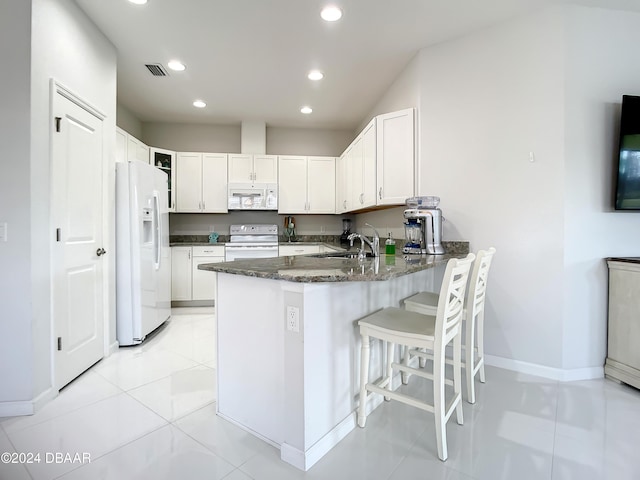 kitchen with kitchen peninsula, white appliances, sink, white cabinets, and light tile patterned flooring