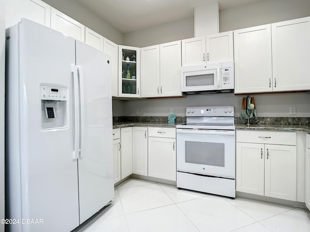 kitchen with white cabinets, light tile patterned flooring, and white appliances