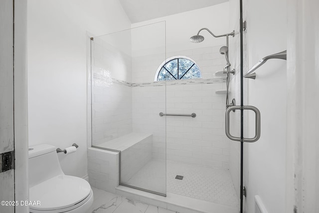 bathroom featuring toilet and a shower with door