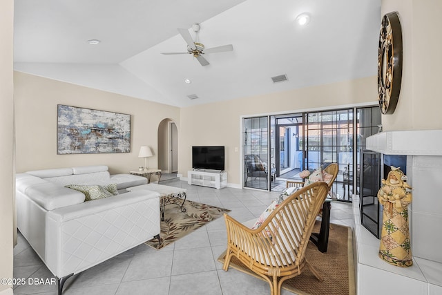 tiled living room with ceiling fan and vaulted ceiling