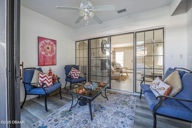 sitting room featuring wood-type flooring and ceiling fan