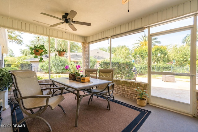 sunroom / solarium with plenty of natural light, outdoor dining space, and ceiling fan
