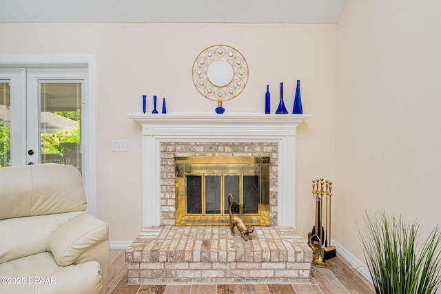 details featuring baseboards, french doors, wood finished floors, and a fireplace