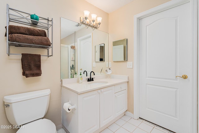 bathroom featuring a shower stall, tile patterned flooring, toilet, vanity, and baseboards