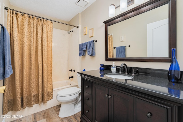 bathroom featuring wood finished floors, vanity, shower / bath combination with curtain, toilet, and visible vents