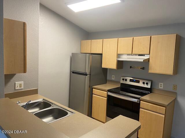 940 Village Trl Unit 6-305, Port Orange, FL 32127 - kitchen with black range with electric stovetop, light brown cabinetry, under cabinet range hood, freestanding refrigerator, and light countertops