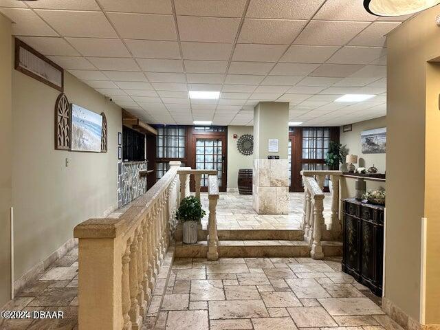 3501 S Atlantic Ave E Unit G20, Daytona Beach Shores, FL 32118 - hallway with stone tile floors, baseboards, and a paneled ceiling