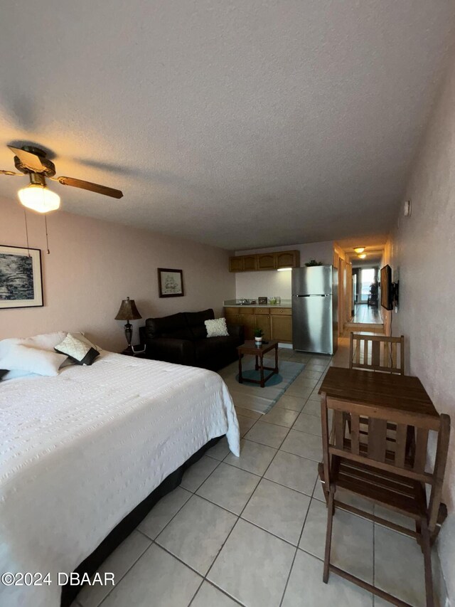3501 S Atlantic Ave E Unit G20, Daytona Beach Shores, FL 32118 - bedroom featuring freestanding refrigerator, light tile patterned floors, and a textured ceiling
