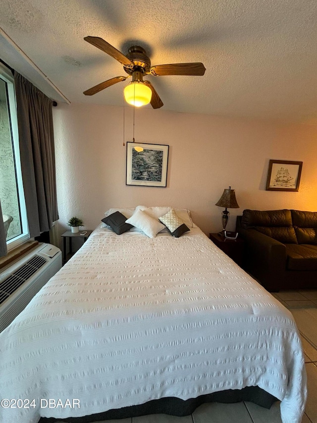 tiled bedroom with ceiling fan and a textured ceiling