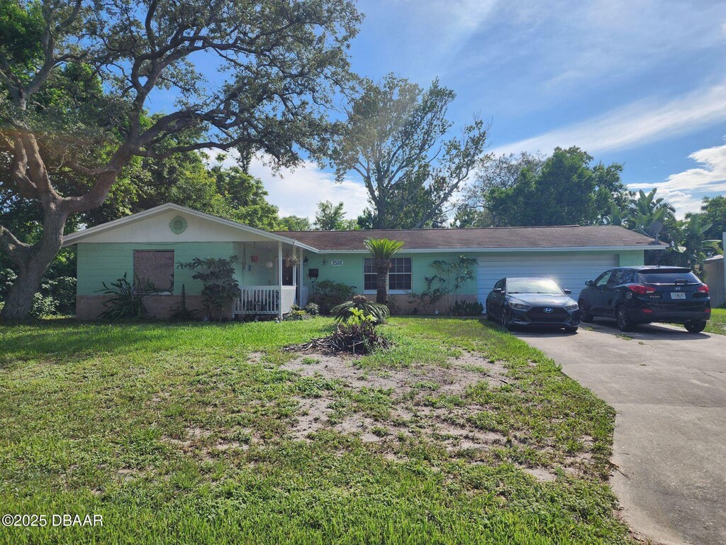 1528 Valencia Ave, Daytona Beach, FL 32117 - ranch-style home featuring a front lawn, a garage, and driveway