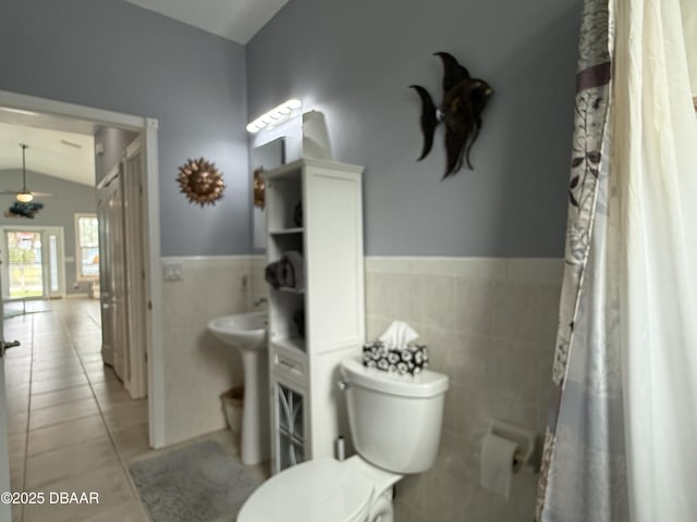415 Jessamine Ave, New Smyrna Beach, FL 32169 - full bathroom with tile walls, toilet, lofted ceiling, tile patterned flooring, and wainscoting