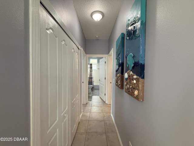 415 Jessamine Ave, New Smyrna Beach, FL 32169 - hall featuring light tile patterned floors, baseboards, and a textured ceiling