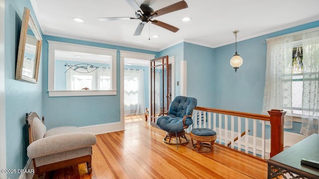 living area featuring crown molding and hardwood / wood-style floors