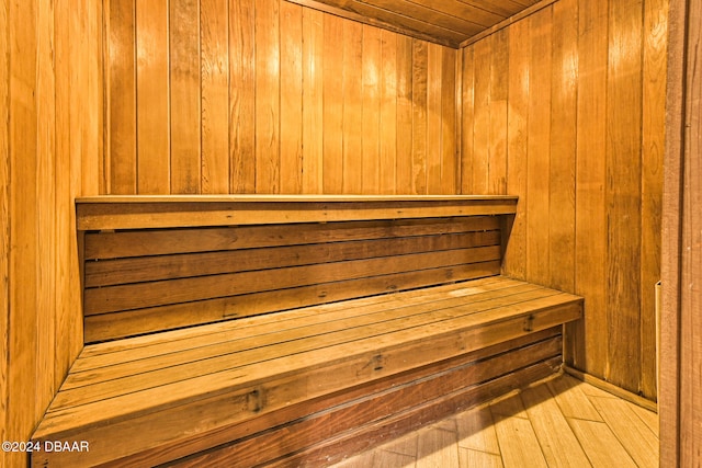 view of sauna / steam room with wood walls, hardwood / wood-style floors, and wooden ceiling