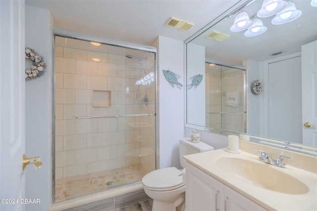 bathroom featuring toilet, hardwood / wood-style floors, and a shower with shower door