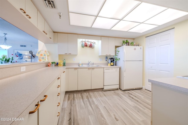 kitchen with hanging light fixtures, sink, white cabinetry, light hardwood / wood-style flooring, and white appliances