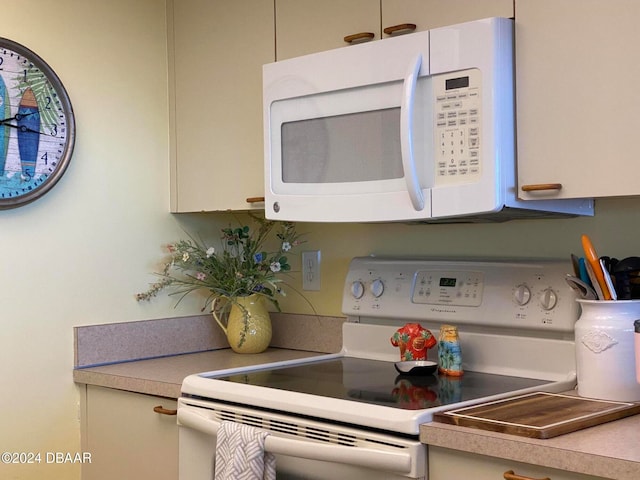 kitchen with white cabinetry and white appliances