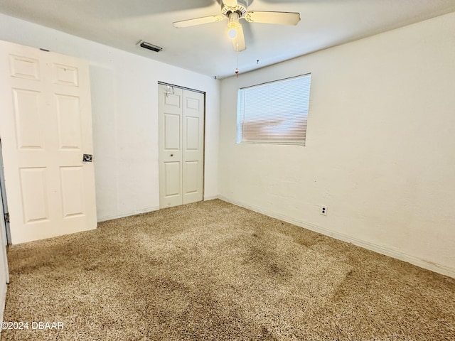 unfurnished bedroom featuring carpet floors, a closet, and ceiling fan