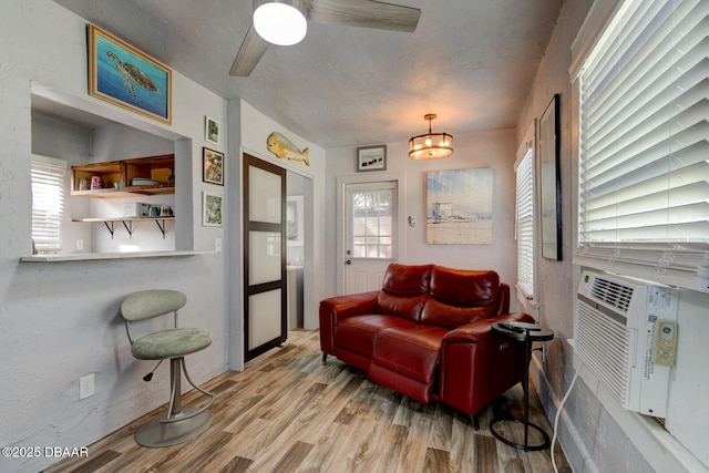 living room with a textured ceiling, light hardwood / wood-style flooring, and a healthy amount of sunlight