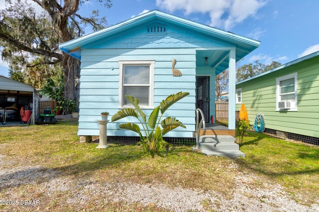 bungalow-style home with cooling unit and a front lawn