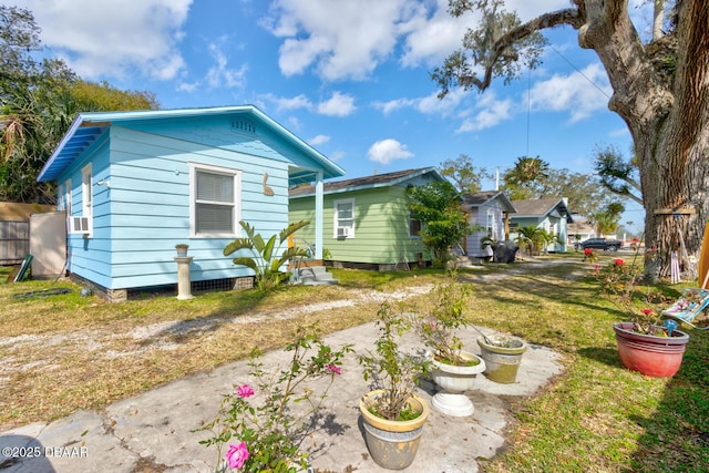 back of house with cooling unit and a yard