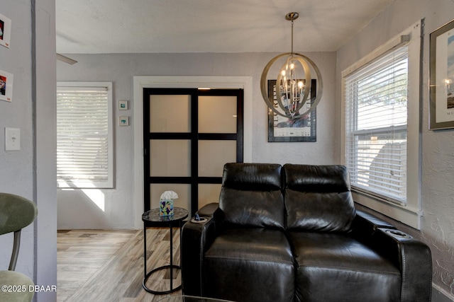 living area with a notable chandelier and light hardwood / wood-style flooring