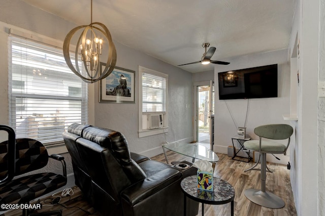 living room featuring wood-type flooring and ceiling fan with notable chandelier