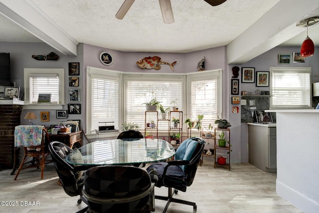 dining space featuring light hardwood / wood-style floors, a textured ceiling, and a wealth of natural light