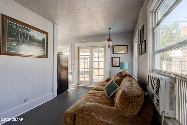 living room with cooling unit, a textured ceiling, and french doors